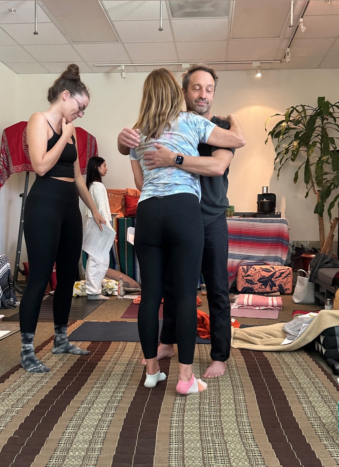Two participants embracing in a warm, supportive moment after a session.