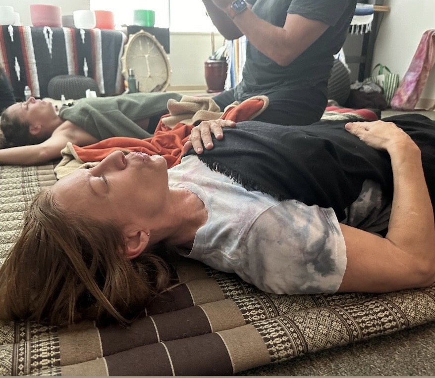 Participants resting on mats during a breathwork session, deeply relaxed.